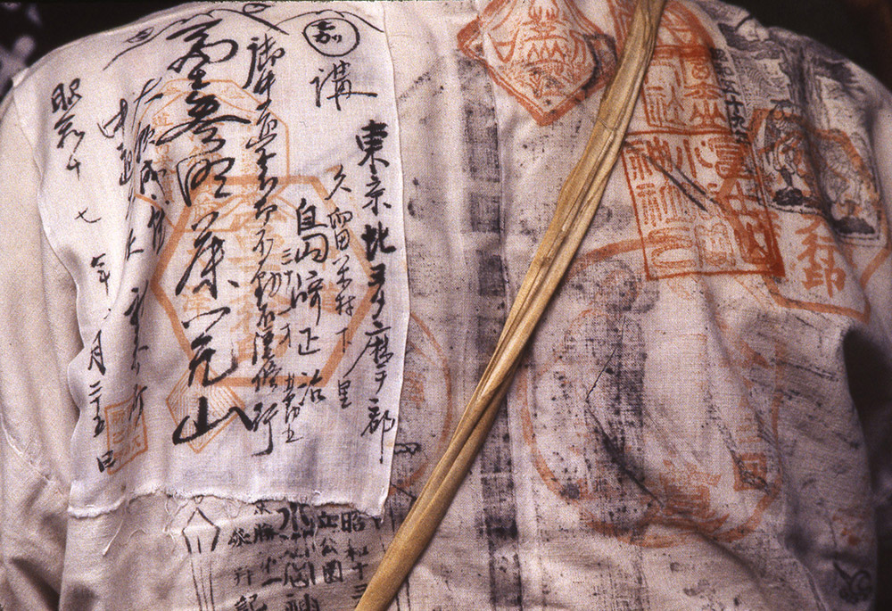 White garment worn by participants at the opening of the climbing season at Mt. Fuji. It is covered with seals and characters that purify and protect the wearer’s body with their magic power.